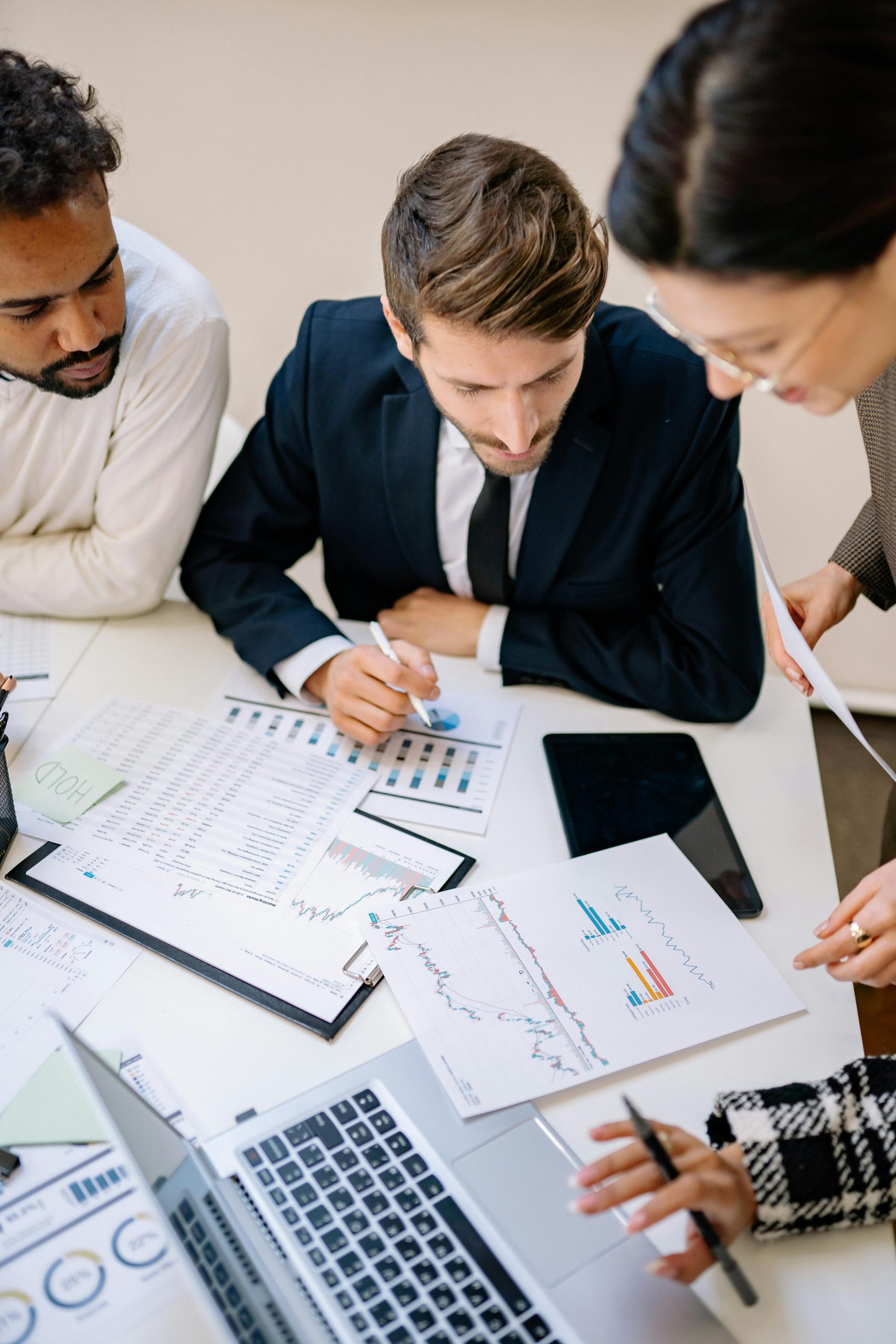 Development partners celebrating a successful project milestone while reviewing digital reports on a laptop.