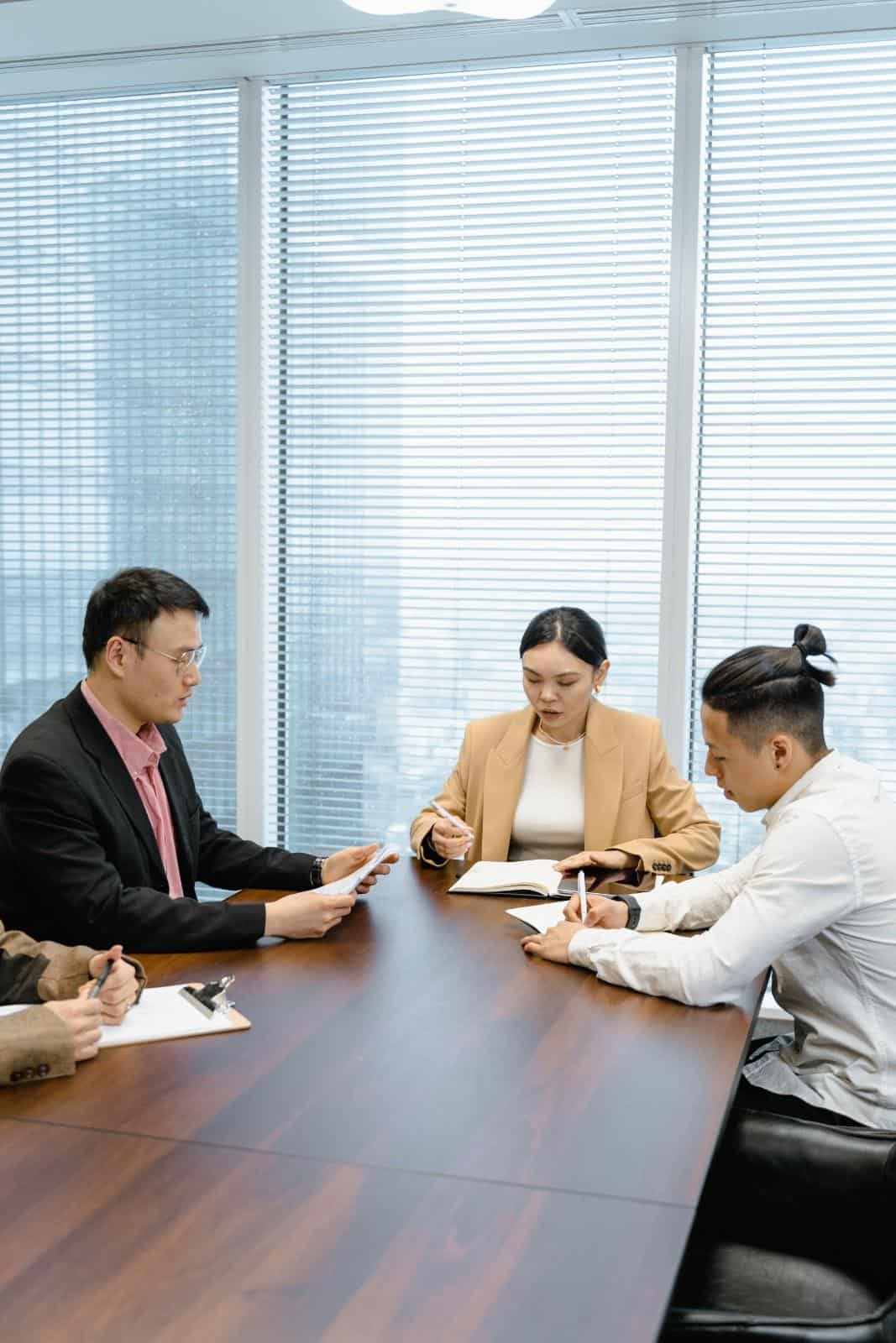 HR consultants meeting with clients in a modern conference room to discuss employment law.